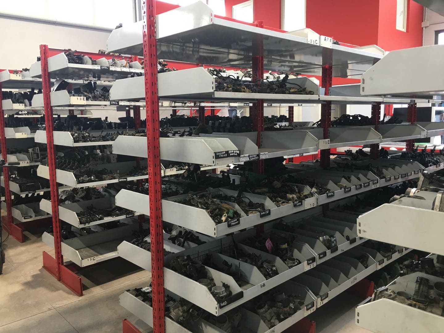 Scaffali con cassette di componenti divise ed etichettate per marca del veicolo