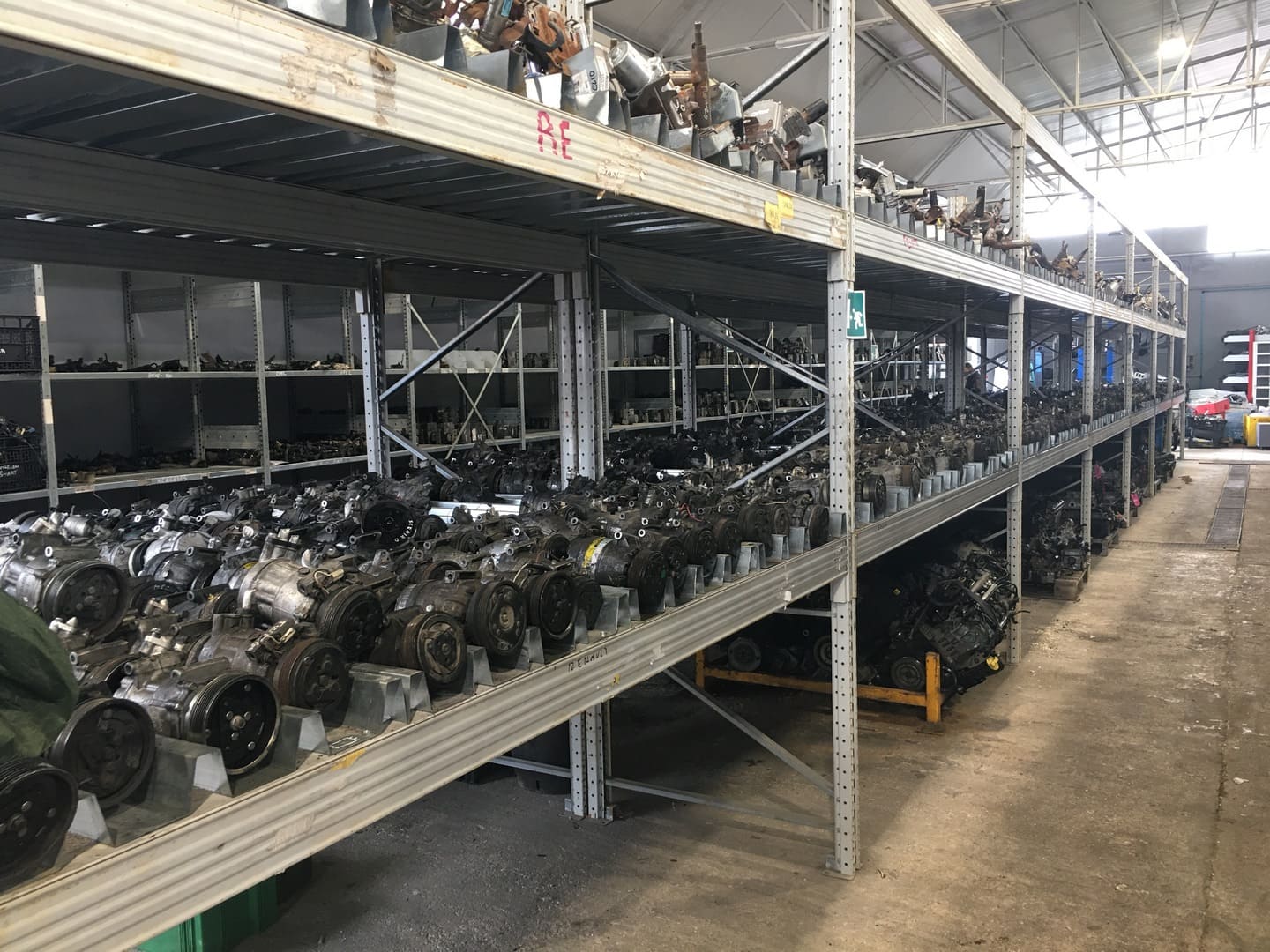 Corridoio del magazzino con scaffalature piene di compressori aria condizionata e motori