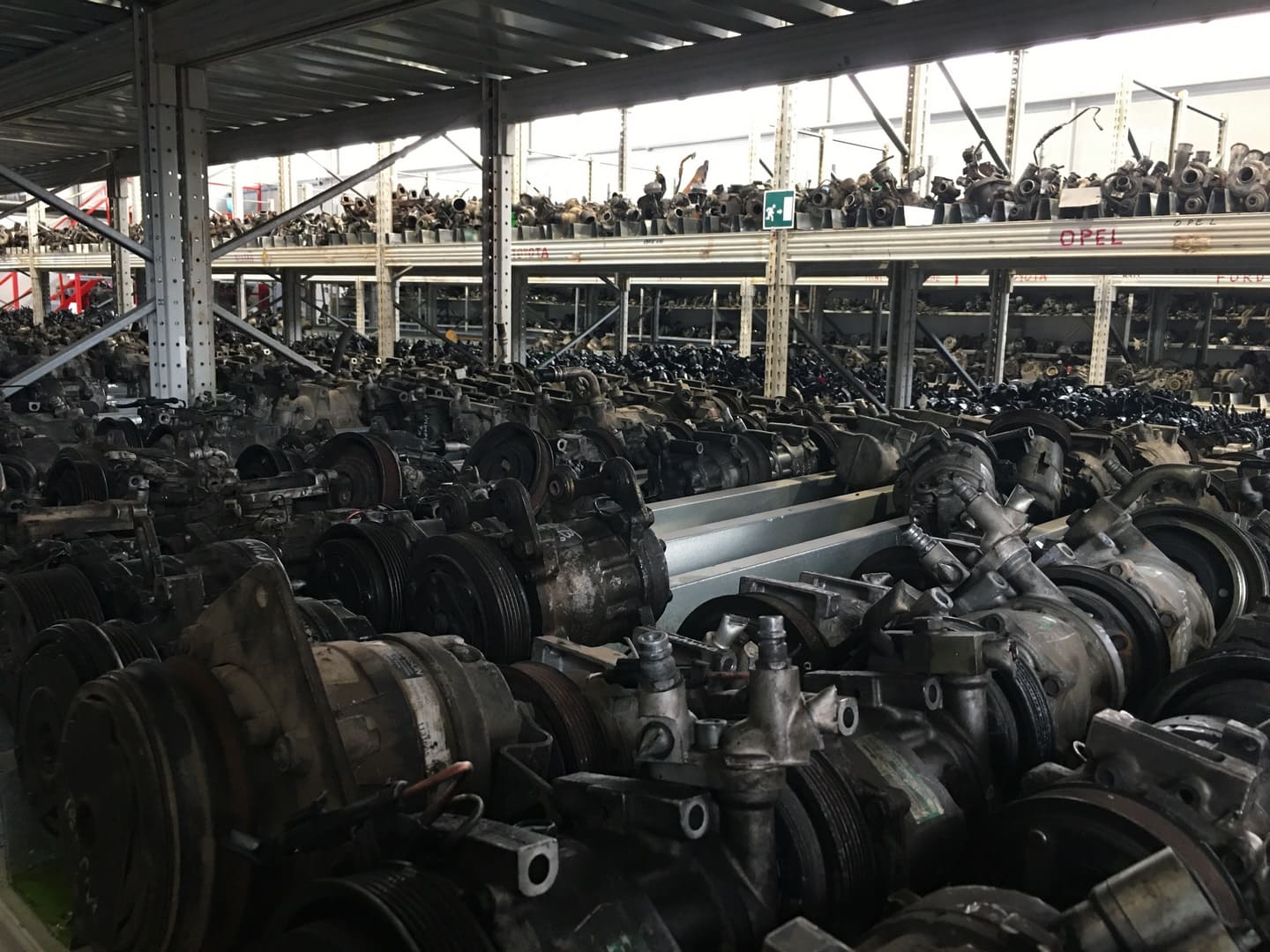 Compressori e pompe servosterzo allineati sugli scaffali, divisi per marca